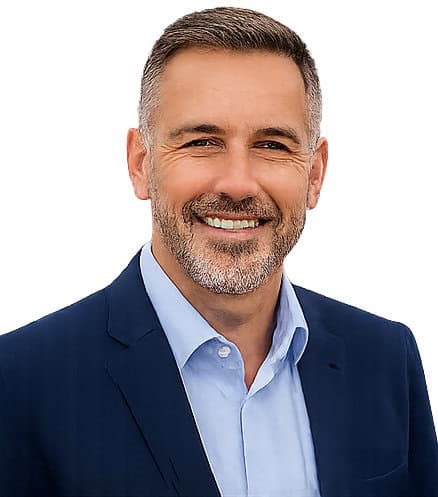 Smiling middle-aged man in a navy suit and light blue shirt.