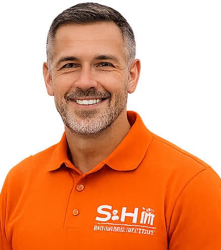 Smiling man wearing orange polo shirt with company logo for web design.
